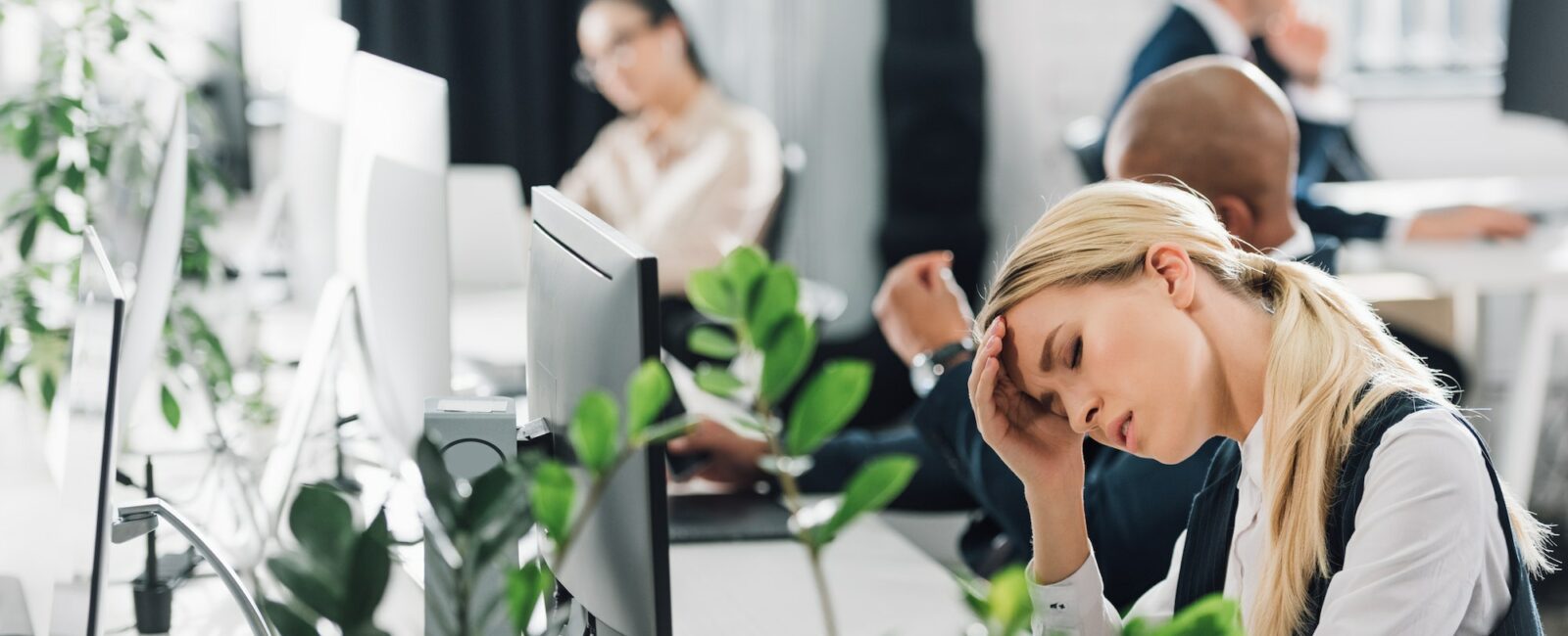 sick young woman suffering from headache at workplace